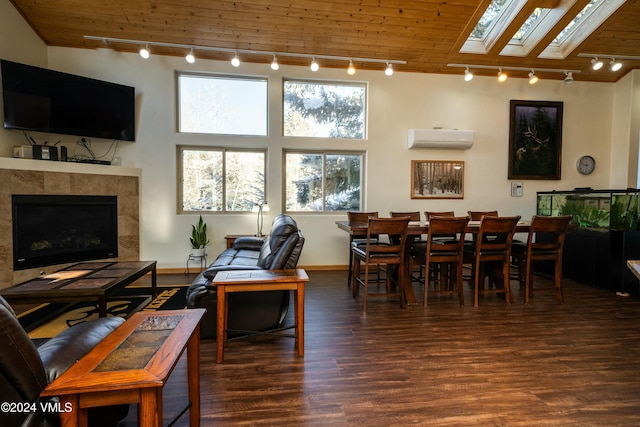 living room featuring a tile fireplace, dark hardwood / wood-style floors, a wall mounted air conditioner, a skylight, and track lighting