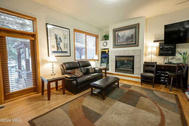 living room featuring hardwood / wood-style flooring and a tiled fireplace