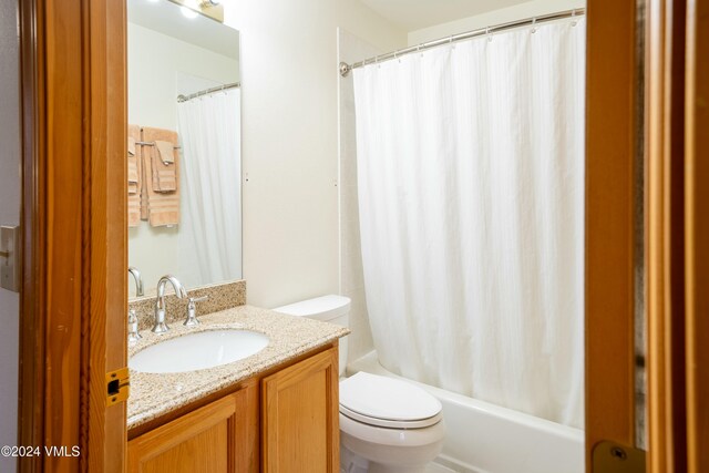 full bathroom with shower / bathtub combination with curtain, vanity, and toilet