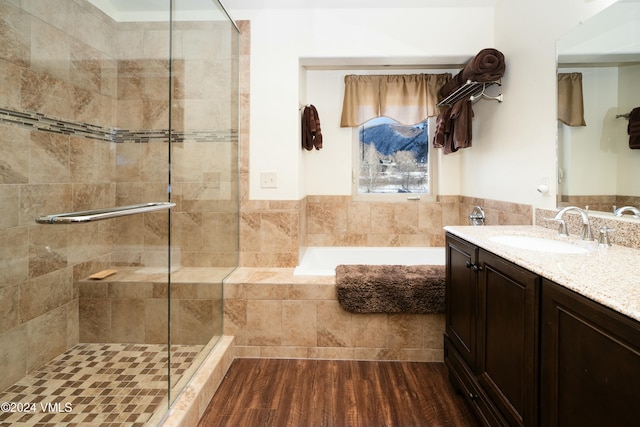 bathroom featuring vanity, wood-type flooring, and separate shower and tub