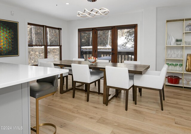 dining space featuring french doors, a wealth of natural light, and light hardwood / wood-style flooring