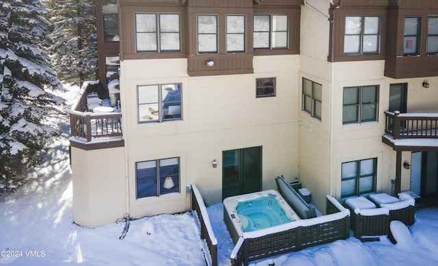 view of snow covered back of property