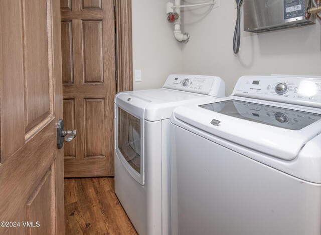 clothes washing area featuring separate washer and dryer and dark wood-type flooring