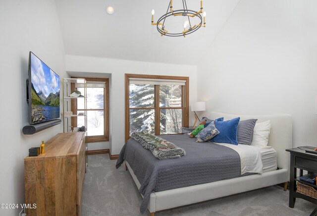 carpeted bedroom featuring an inviting chandelier and lofted ceiling