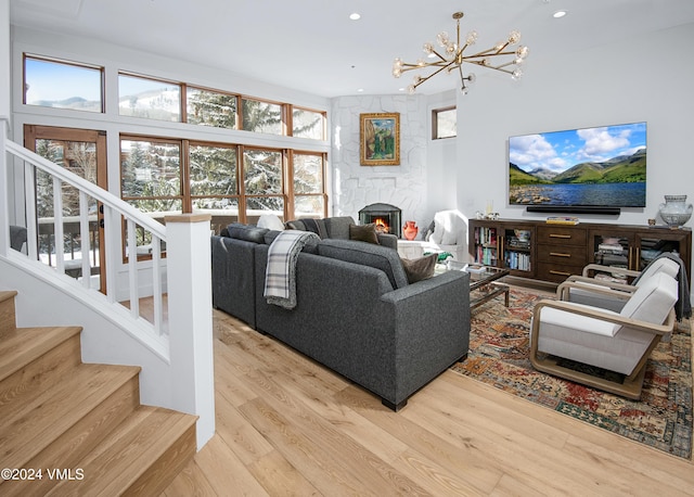 living room with a fireplace, light hardwood / wood-style floors, and a notable chandelier