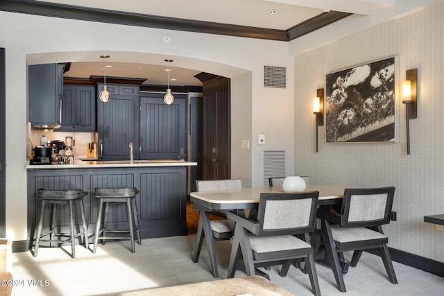 dining room featuring crown molding, light colored carpet, and sink