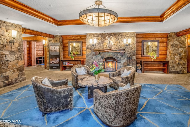 living room featuring a tray ceiling, a fireplace, and a textured ceiling