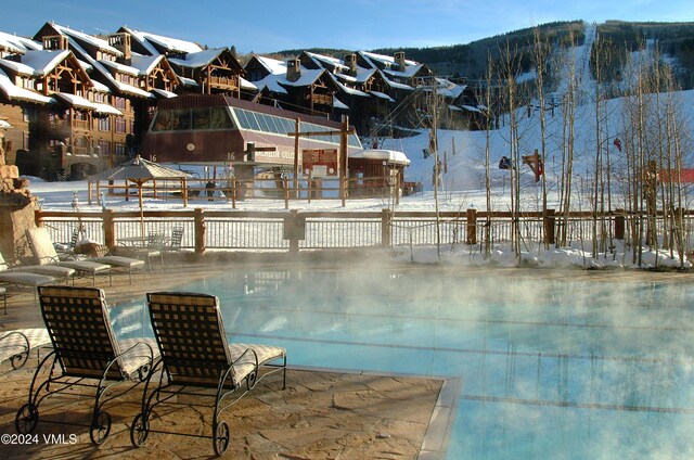 snow covered pool with a mountain view and a gazebo