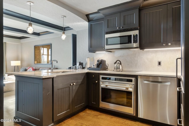 kitchen featuring light hardwood / wood-style flooring, appliances with stainless steel finishes, beam ceiling, decorative light fixtures, and kitchen peninsula