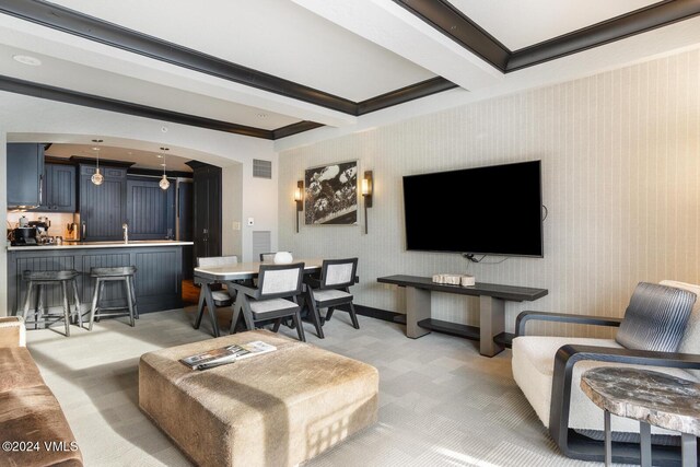 living room featuring crown molding, light colored carpet, and beamed ceiling