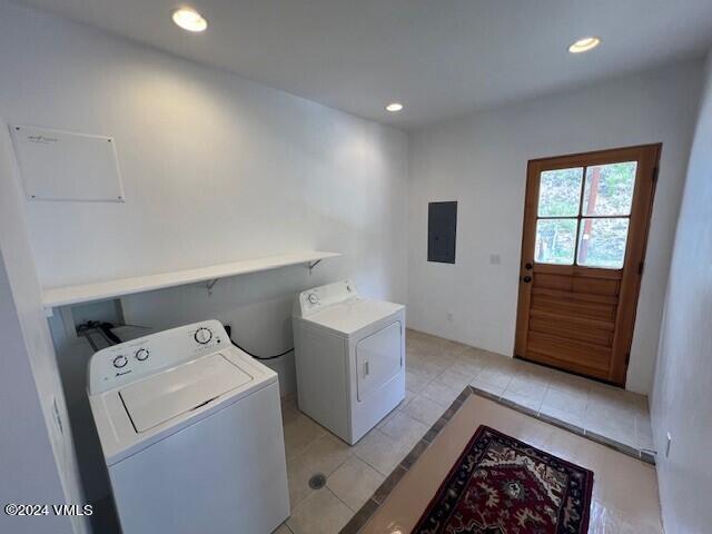 laundry area with light tile patterned flooring, separate washer and dryer, and electric panel