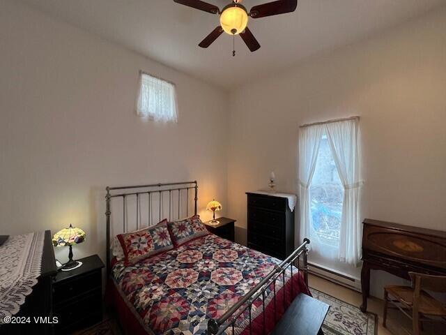 bedroom with ceiling fan and baseboard heating