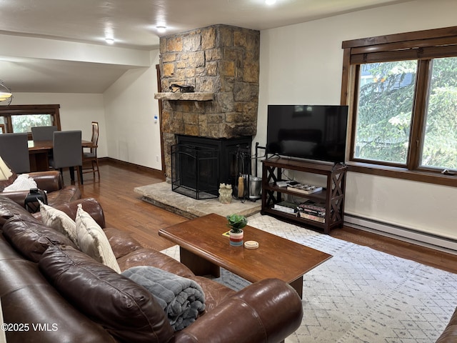 83 Larkspur Ln Unit A, Avon, CO 81620 - living room with wood finished floors, a baseboard heating unit, plenty of natural light, a stone fireplace, and lofted ceiling