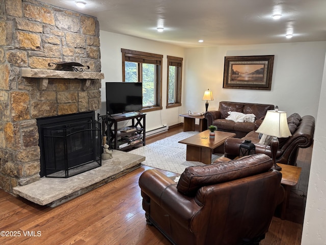 83 Larkspur Ln Unit A, Avon, CO 81620 - living room featuring wood finished floors, a baseboard heating unit, and a stone fireplace