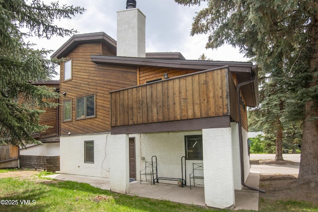 83 Larkspur Ln Unit A, Avon, CO 81620 - back of house with a chimney, a patio area, and stucco siding