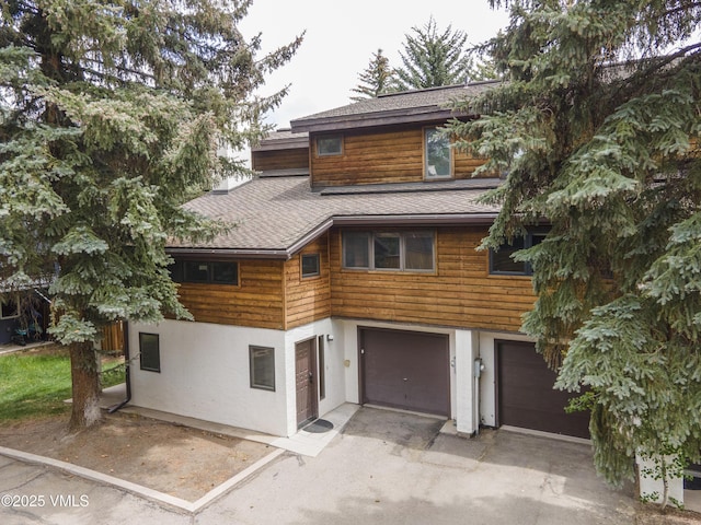 83 Larkspur Ln Unit A, Avon, CO 81620 - rustic home with a shingled roof, stucco siding, an attached garage, and asphalt driveway