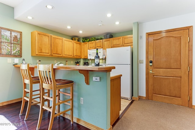 74 Cresta Rd Unit 110, Edwards, CO 81632 - kitchen featuring white appliances, a kitchen breakfast bar, recessed lighting, light countertops, and a peninsula