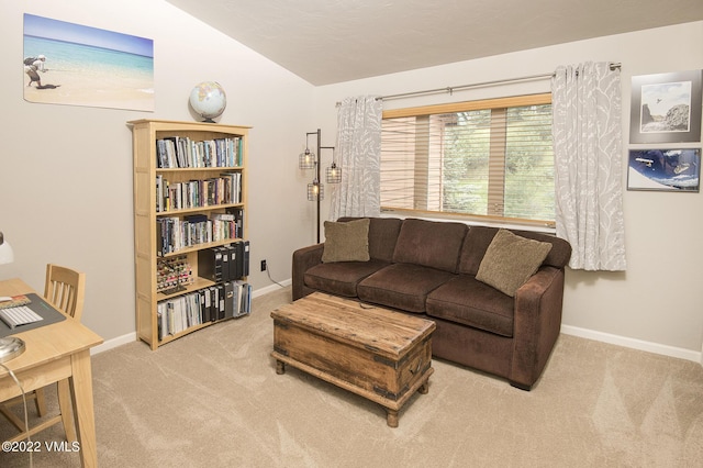 carpeted living room featuring baseboards and lofted ceiling