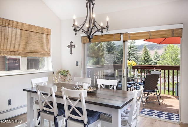 dining space featuring vaulted ceiling, wood finished floors, and a chandelier