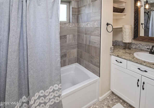 full bath featuring vanity, baseboards, and shower / bath combo