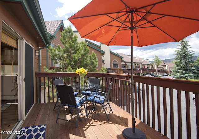 wooden terrace featuring a residential view and outdoor dining area