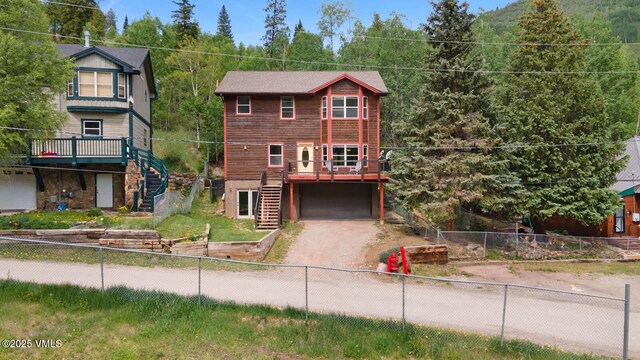 445 Pine St, Red Cliff, CO 81649 - view of front facade featuring stairway, driveway, a deck, a garage, and a fenced backyard
