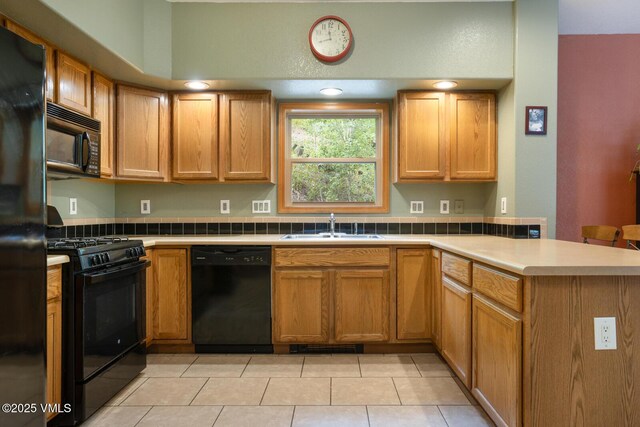 445 Pine St, Red Cliff, CO 81649 - kitchen with black appliances, a peninsula, light tile patterned floors, light countertops, and brown cabinets