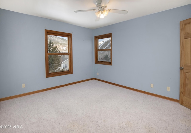 carpeted spare room featuring ceiling fan