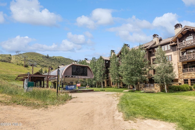 view of home's community featuring a mountain view and a yard