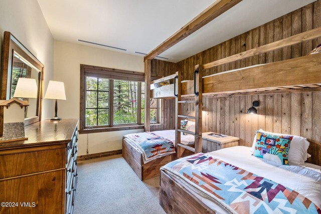 carpeted bedroom featuring wood walls