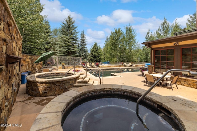 view of swimming pool with an in ground hot tub and a patio area