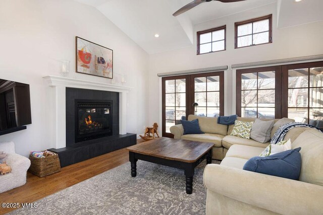 50 Bunker Way, Eagle, CO 81631 - living room with french doors, high vaulted ceiling, a tiled fireplace, a ceiling fan, and wood finished floors