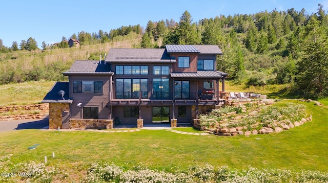 620 Jouflas Ranch Rd, Wolcott, CO 81655 - back of property featuring a standing seam roof, a lawn, stone siding, asphalt driveway, and a patio