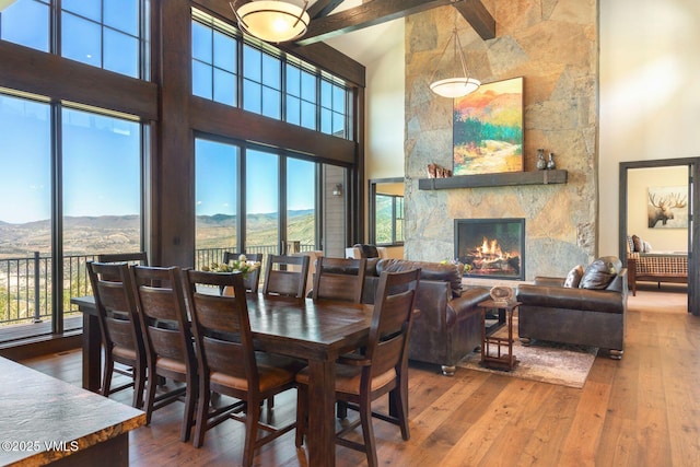 620 Jouflas Ranch Rd, Wolcott, CO 81655 - dining space with a towering ceiling, hardwood / wood-style flooring, a mountain view, a stone fireplace, and plenty of natural light