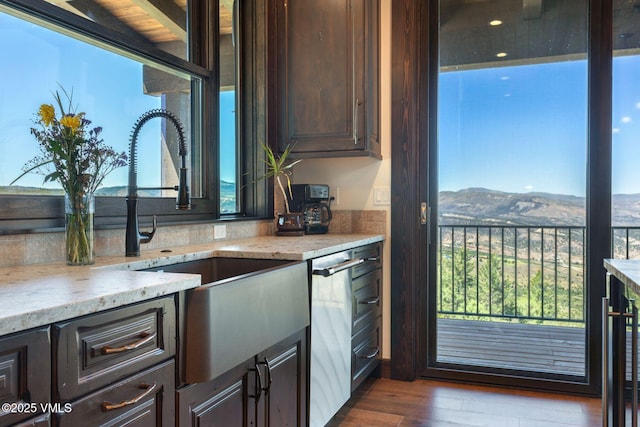 620 Jouflas Ranch Rd, Wolcott, CO 81655 - kitchen featuring dark brown cabinetry, a mountain view, stainless steel dishwasher, light stone counters, and dark wood finished floors