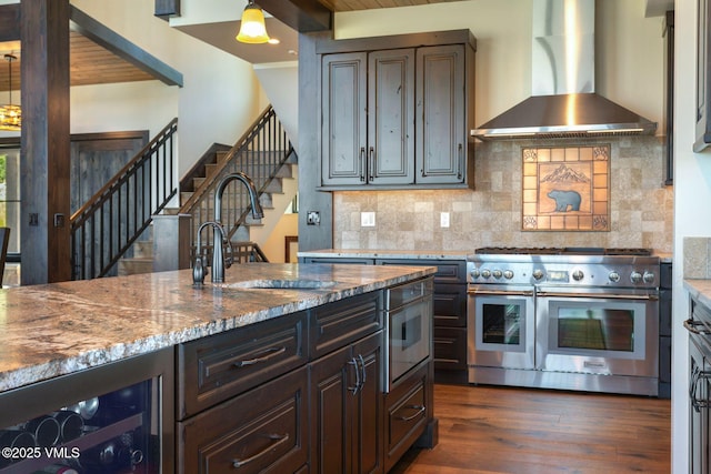 620 Jouflas Ranch Rd, Wolcott, CO 81655 - kitchen with range with two ovens, wall chimney range hood, beverage cooler, light stone countertops, and tasteful backsplash