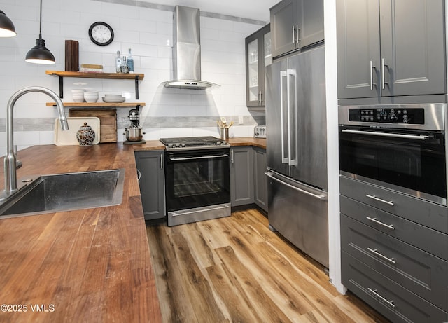 175 Hurd Ln Unit 3101, Avon, CO 81620 - kitchen featuring appliances with stainless steel finishes, butcher block counters, wall chimney exhaust hood, and a sink