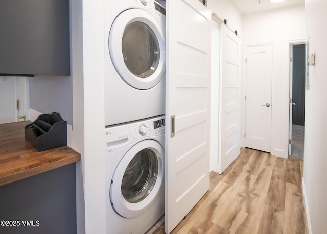 175 Hurd Ln Unit 3101, Avon, CO 81620 - laundry room with stacked washer / drying machine, light wood-style flooring, and a barn door