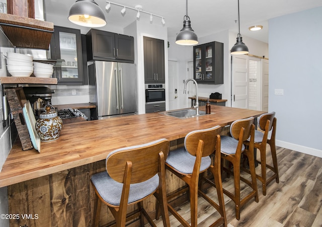 175 Hurd Ln Unit 3101, Avon, CO 81620 - kitchen featuring stainless steel appliances, wooden counters, a sink, wood finished floors, and glass insert cabinets
