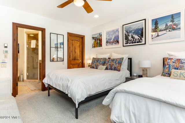 bedroom with light carpet, connected bathroom, and ceiling fan