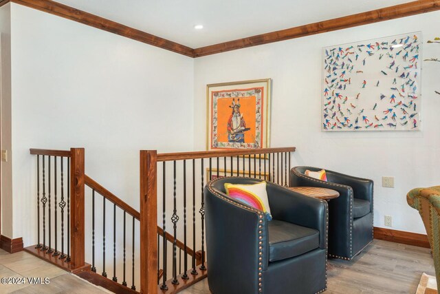 living area with ornamental molding and hardwood / wood-style floors