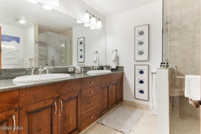 bathroom featuring tile patterned flooring, vanity, and a shower with door