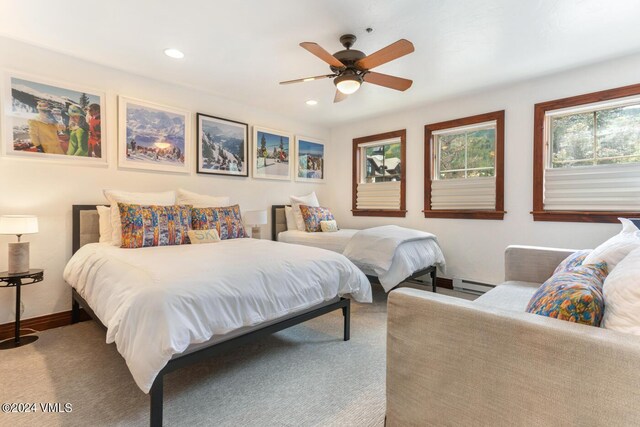 carpeted bedroom with ceiling fan and baseboard heating