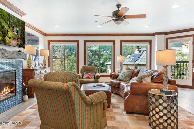 living room featuring a fireplace, ornamental molding, and ceiling fan