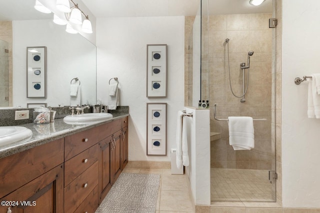 bathroom with an enclosed shower, vanity, and tile patterned floors