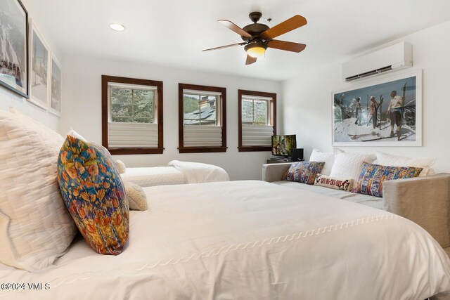 bedroom with ceiling fan and a wall unit AC