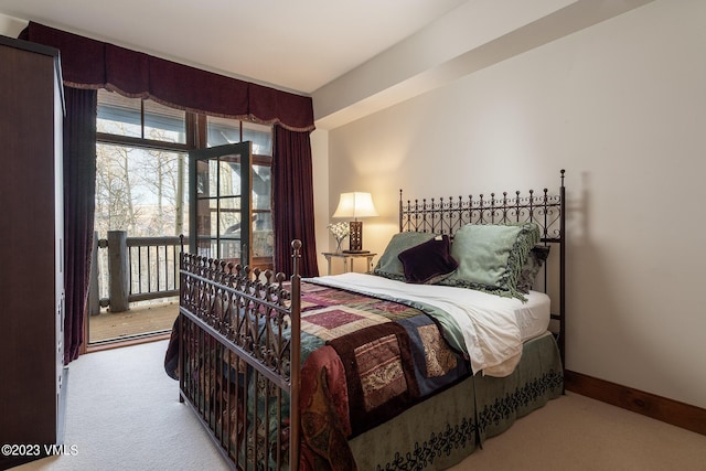 carpeted bedroom featuring baseboards and access to exterior