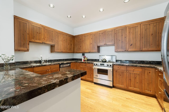 kitchen featuring gas range, dishwasher, light wood-type flooring, recessed lighting, and a sink