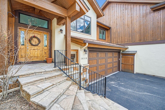 2900 June Creek Trl Unit B, Avon, CO 81620 - entrance to property featuring asphalt driveway, an attached garage, and stucco siding
