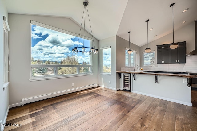2900 June Creek Trl Unit B, Avon, CO 81620 - kitchen with a baseboard radiator, beverage cooler, vaulted ceiling, dark wood-style flooring, and a breakfast bar